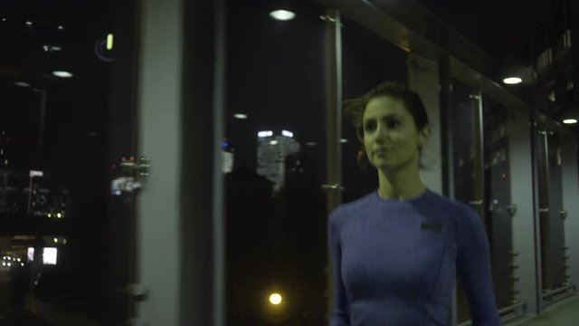 Young adult female jogging in city at night