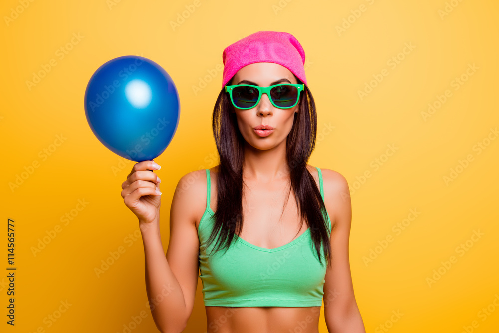 Sticker cheerful hipster girl in pink hat holding balloon on yellow wal