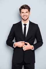 Cheerful happy man buttoning his black suit