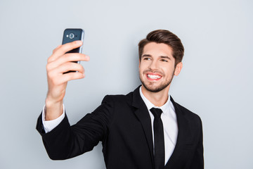 Handsome smiling man in black suit making selfie