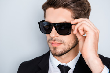 Portrait of handsome confident man touching his glasses