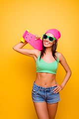 Portrait of attractive young hipster woman holding pink longboar