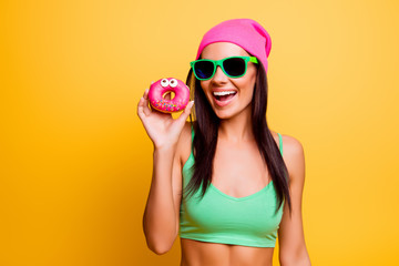 beautiful excited hipster girl in pink hat  holding pink donut o