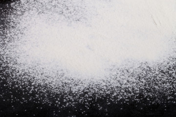 Flour spilling on black background