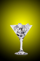 Ice cubes in martini glass on color background