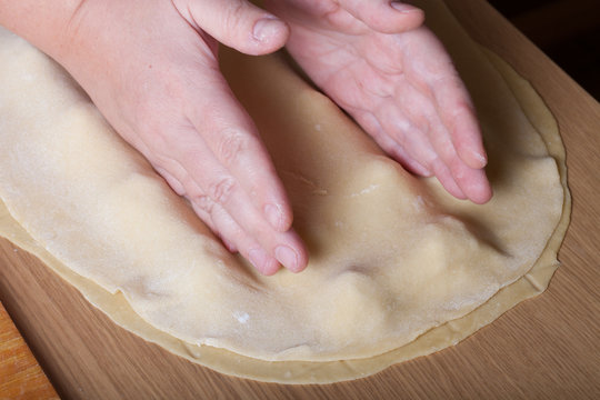 Female hands cut up dough