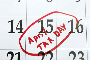 April tax day written and circled in a calender on date of 15th, close up