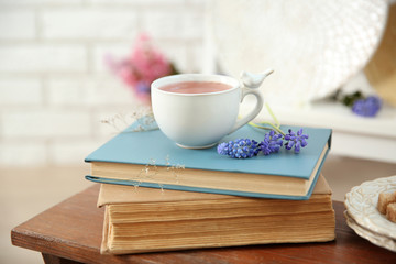 Books, cup of tea on wooden table