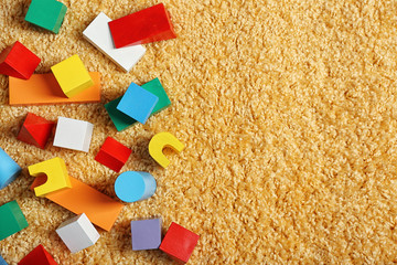 Colorful wooden kids toys on carpet