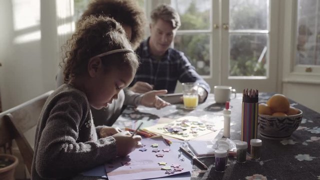 Parents with daughter drawing in living room