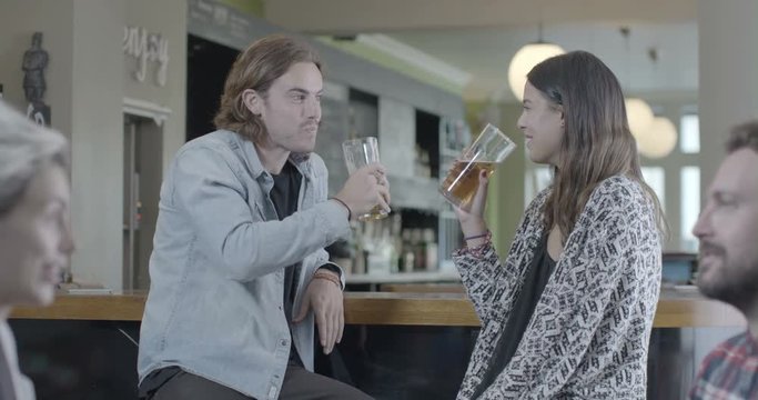 Man and woman enjoying beer and talking in pub