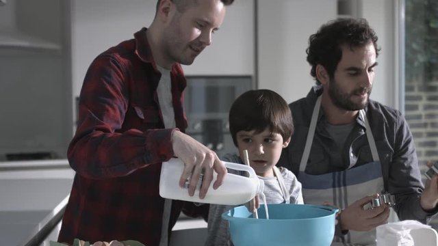 Same sex couple family cooking biscuits