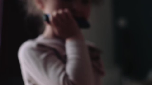 Girl playing harmonica with sister