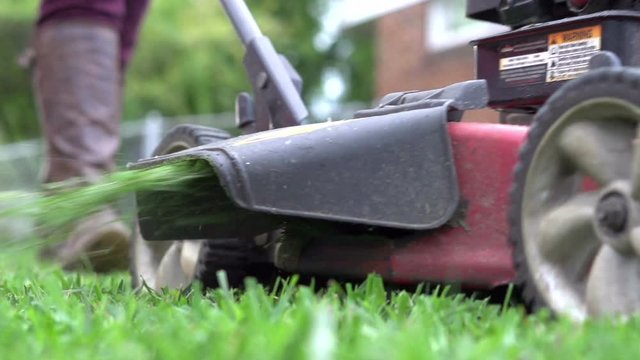 Lawn mower drives by shooting grass out side in slow motion @ 240fps played at 29.97 fps.