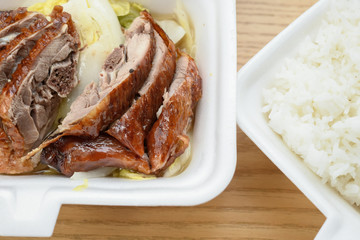 lunch box of roasted duck and  another box of rice on table