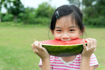 Asian child eating watermelon