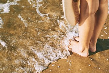Feet of woman standing on the beach