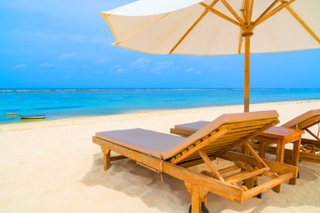 Obraz premium Outdoor daybed recliner with white umbrella on a tropical beach in Asia