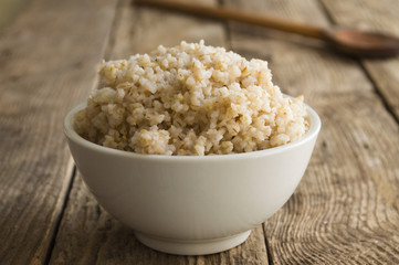Porridge crushed wheat on a wooden background