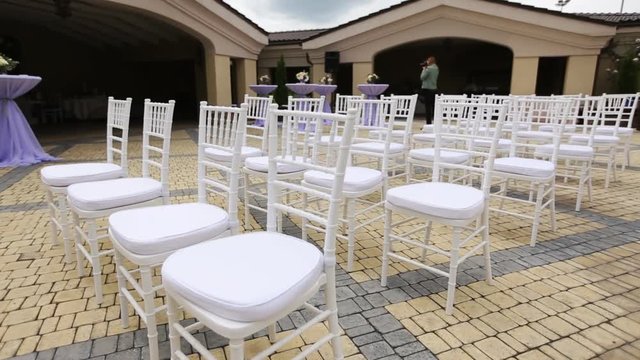 Dolly of rows of chairs at a wedding ceremony from the aisle and from the back