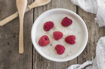 A healthy breakfast . Milk porridge with raspberries