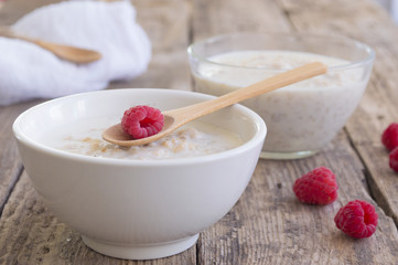 A healthy breakfast . Milk porridge with raspberries