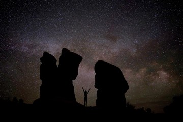 Naked woman silhouette against night sky with Milky Way, constellations and stars. Devil's Garden,...
