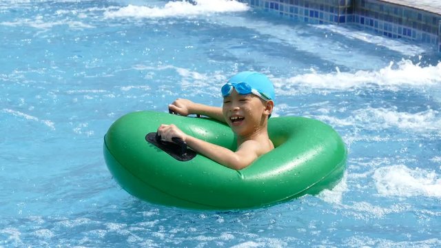 Young asian boy happy on buoy in pool
