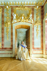 Naklejka premium Historical cosplay. Beautiful woman in the similitude of Catherine the Great, empress of Russia ancient dress in the palace