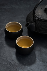 Asian style, cup and teapot with green tea, vertical