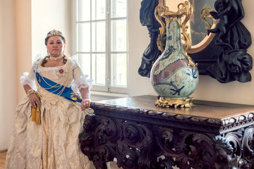 Historical cosplay. Beautiful woman in the similitude of Catherine the Great, empress of Russia ancient dress in the palace