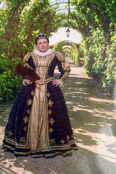 Historical cosplay. Beautiful woman in the similitude of Marguerite of Navarre, queen of France ancient dress in the garden near palace