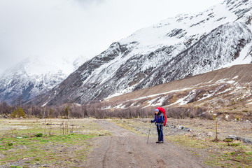 Woman mountain Hiker with backpack enjoy view in Caucasus mountains, Elbrus region, Russia.
