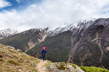 Fototapeta na wymiar Woman mountain Hiker with backpack enjoy view in Caucasus mountains, Elbrus region, Russia.