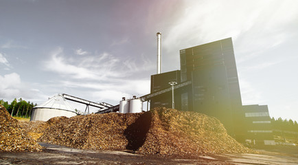 Fototapeta premium bio power plant with storage of wooden fuel against blue sky