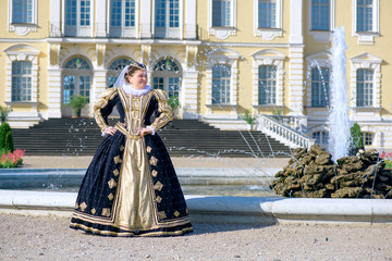 Historical cosplay. Beautiful woman in the similitude of Marguerite of Navarre, queen of France ancient dress in the garden near palace