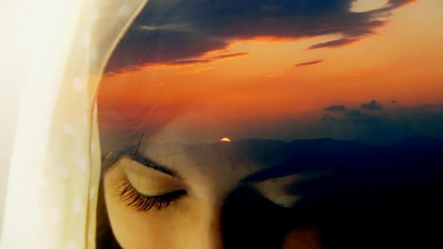 Double exposure: a cute young woman covering her face with a voile, looking at the viewer and glancing; a sunset over snowy mountains; memories of a traveller's journey.