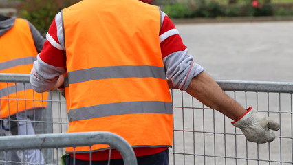 worker with high gloves moves hurdles before the concert event