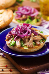 Burger with meat of duck with red onion and lettuce.