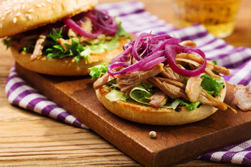 Burger with meat of duck with red onion and lettuce.