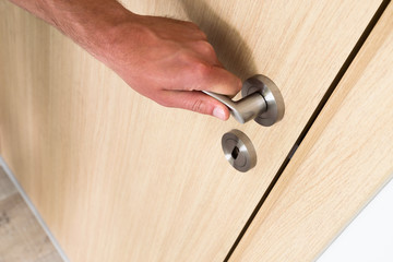 Man opening a wooden household door