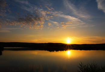 Sunset sky scene over lake with beautiful yellow and blue colors