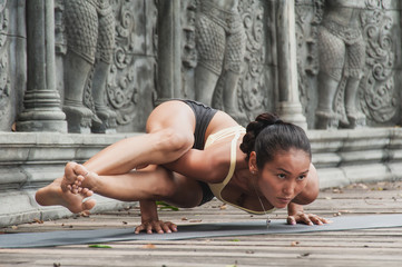 Asian young woman doing hatha yoga in abandoned temple