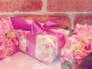 Fototapeta na wymiar gift box present and flowers decoration background with vintage filter color