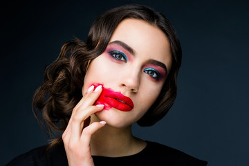 Beautiful young woman in the studio on a black background in the plan in the style of the 20s, vintage, closeup portrait with red lips 