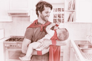 Father and son in superhero costume playing in kitchen