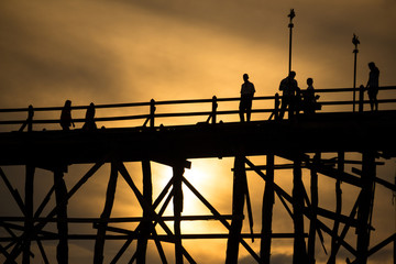 Silluate man on wooden bridge during at sunset