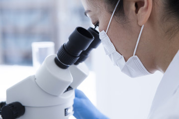 Woman looking through a microscope