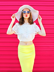 Fashion pretty woman in summer straw hat and skirt over colorful