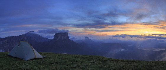Tent in the mountains just before a stunning sunrise.
